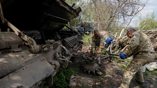 Ukrainian servicemen repair a tank at a position, as Russia's attack on Ukraine continues, in Kharkiv region, Ukraine.(REUTERS)
