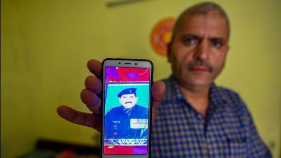 Bal Mukund Choubey shows an old photograph from when he was in the army. (Amal KS/HT)