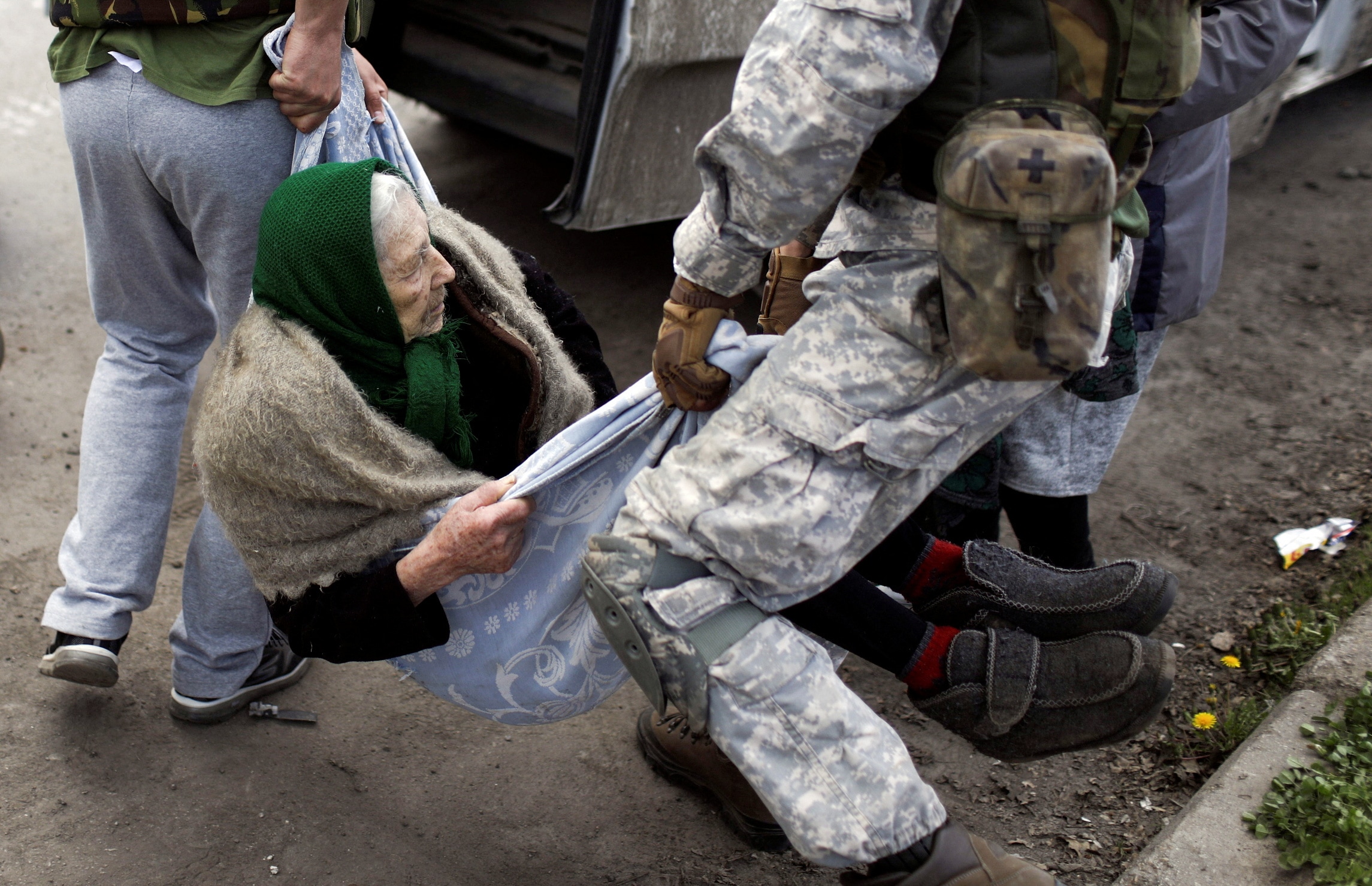 Volunteers carry an elderly woman after they evacuated residents from a village retaken by Ukrainian forces, next to a frontline. (REUTERS)