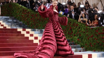 American supermodel Gigi Hadid wore a sultry red corset jumpsuit by Versace and a voluminous matching maroon cape, a creative take on the night's 'Gilded Glamour' theme. (REUTERS)