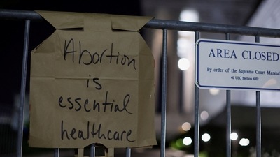 A sign hangs on a fence outside the US Supreme Court as protesters react to the leak of a draft majority opinion written by Justice Samuel Alito preparing for a majority of the court to overturn the landmark Roe v. Wade abortion rights decision. (REUTERS)