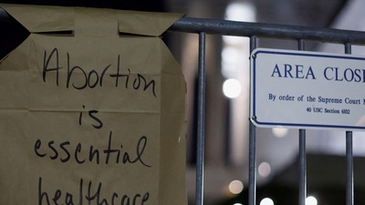 A sign hangs on a fence outside the US Supreme Court as protesters react to the leak of a draft majority opinion written by Justice Samuel Alito preparing for a majority of the court to overturn the landmark Roe v. Wade abortion rights decision. (REUTERS)