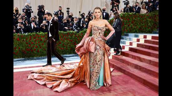 Blake Lively at the Met Gala 2022 red carpet in a rose gold metallic gown by Versace. (AFP)