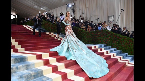 Actor Blake Lively at the Met Gala stairs after transforming the waist bow in her gown to reveal an aqua blue cape. (AFP)