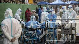 Health workers in PPE suits prepare test kits in a Chinese neighbourhood on Tuesday. (Bloomberg Photo)