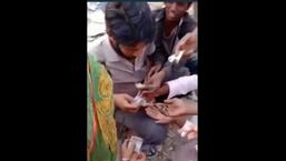A screen grab of the video shared on social media of a drug peddler selling heroin to addicts on a rail track in Faridkot on Wednesday.