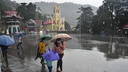 People take a stroll amid showers on The Ridge in Shimla on Wednesday. (Deepak Sansta/Hindustan Times)
