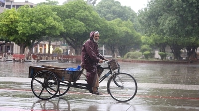 A rikshaw-puller wears raincoat to cover himself amid rains in New Delhi. A rikshaw-puller wears raincoat to cover himself amid rains in New Delhi. 