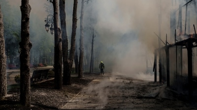 A firefighter works to extinguish a fire following a Russian bombardment at a park in Kharkiv, Ukraine, Tuesday. (AP) A firefighter works to extinguish a fire following a Russian bombardment at a park in Kharkiv, Ukraine, Tuesday. (AP)