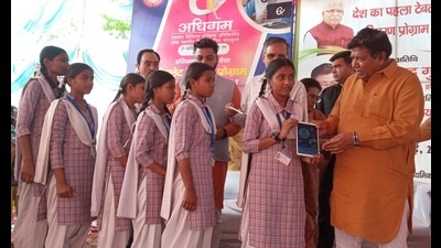 Haryana Vidhan Sabha speaker Gian Chand Gupta distributing tablets among students at Government Girls Senior Secondary School in Sector 15, Panchkula, on Thursday. (Sant Arora/HT)