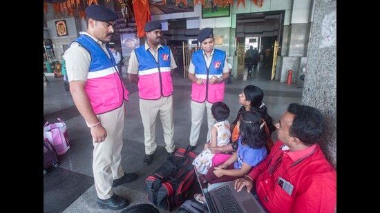 Railway Protection Force (RPF) personnel wearing children-friendly jackets interact with passengers at railway station. (Pratham Gokhale/HT Photo)