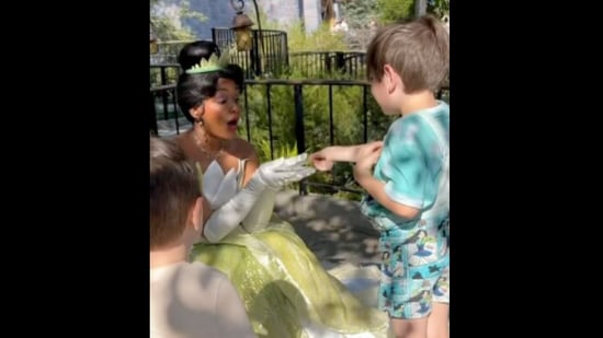 The little boy gives the sticker to Princess Tiana in Disneyland.&nbsp;(instagram/@mommademagic)