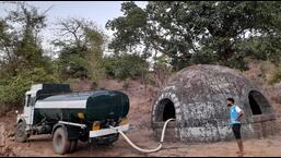 A water tanker filling the well in Biwalwadi village. Kalyan resident group, Mi Kalyankar has organised three tankers for the water-hit villagers daily. (HT PHOTO)