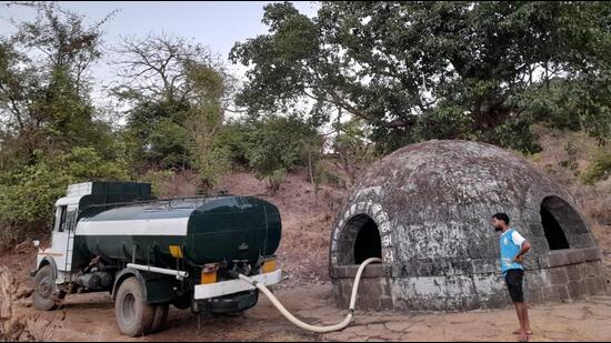 A water tanker filling the well in Biwalwadi village. Kalyan resident group, Mi Kalyankar has organised three tankers for the water-hit villagers daily. (HT PHOTO)