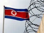 FILE PHOTO: A North Korea flag flutters next to concertina wire at the North Korean embassy