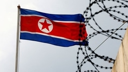 FILE PHOTO: A North Korea flag flutters next to concertina wire at the North Korean embassy