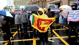 A demonstrator holds Sri Lanka's national flag as he takes part in a protest against the economic crisis in Colombo.&nbsp;