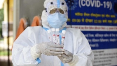 A health worker shows the collected swab sample (Parveen Kumar/HT Photo)