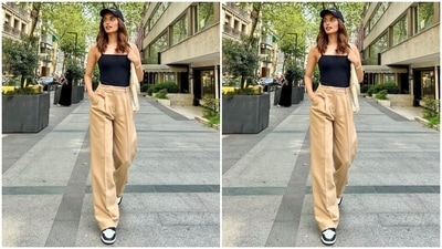 The photo shows Manushi dressed in a simply trendy top in a solid black colour with barely-there straps, a square neckline and a bodycon silhouette. She teamed it with beige pants featuring a high-rise waistline, belt hoops, tailored pleats, flared hem, and pockets on the side. (Instagram/@manushi_chhillar) The photo shows Manushi dressed in a simply trendy top in a solid black colour with barely-there straps, a square neckline and a bodycon silhouette. She teamed it with beige pants featuring a high-rise waistline, belt hoops, tailored pleats, flared hem, and pockets on the side. (Instagram/@manushi_chhillar)