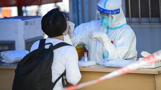 A resident undergoes a nucleic acid test for the Covid-19 coronavirus in Guangzhou, in China's southern Guangdong province on May 7, 2022. (Photo by AFP)