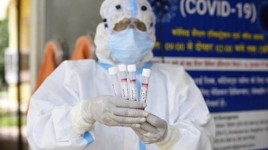 A health worker shows the collected swab sample(Parveen Kumar/HT Photo)