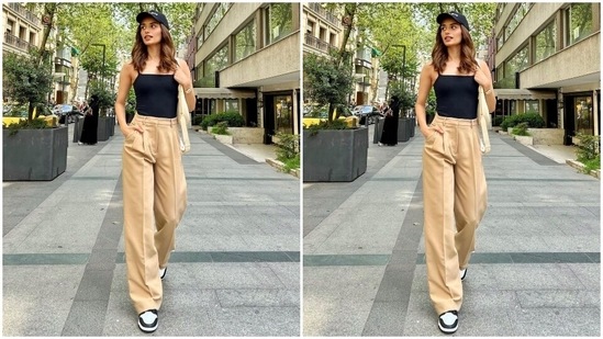 The photo shows Manushi dressed in a simply trendy top in a solid black colour with barely-there straps, a square neckline and a bodycon silhouette. She teamed it with beige pants featuring a high-rise waistline, belt hoops, tailored pleats, flared hem, and pockets on the side.(Instagram/@manushi_chhillar)