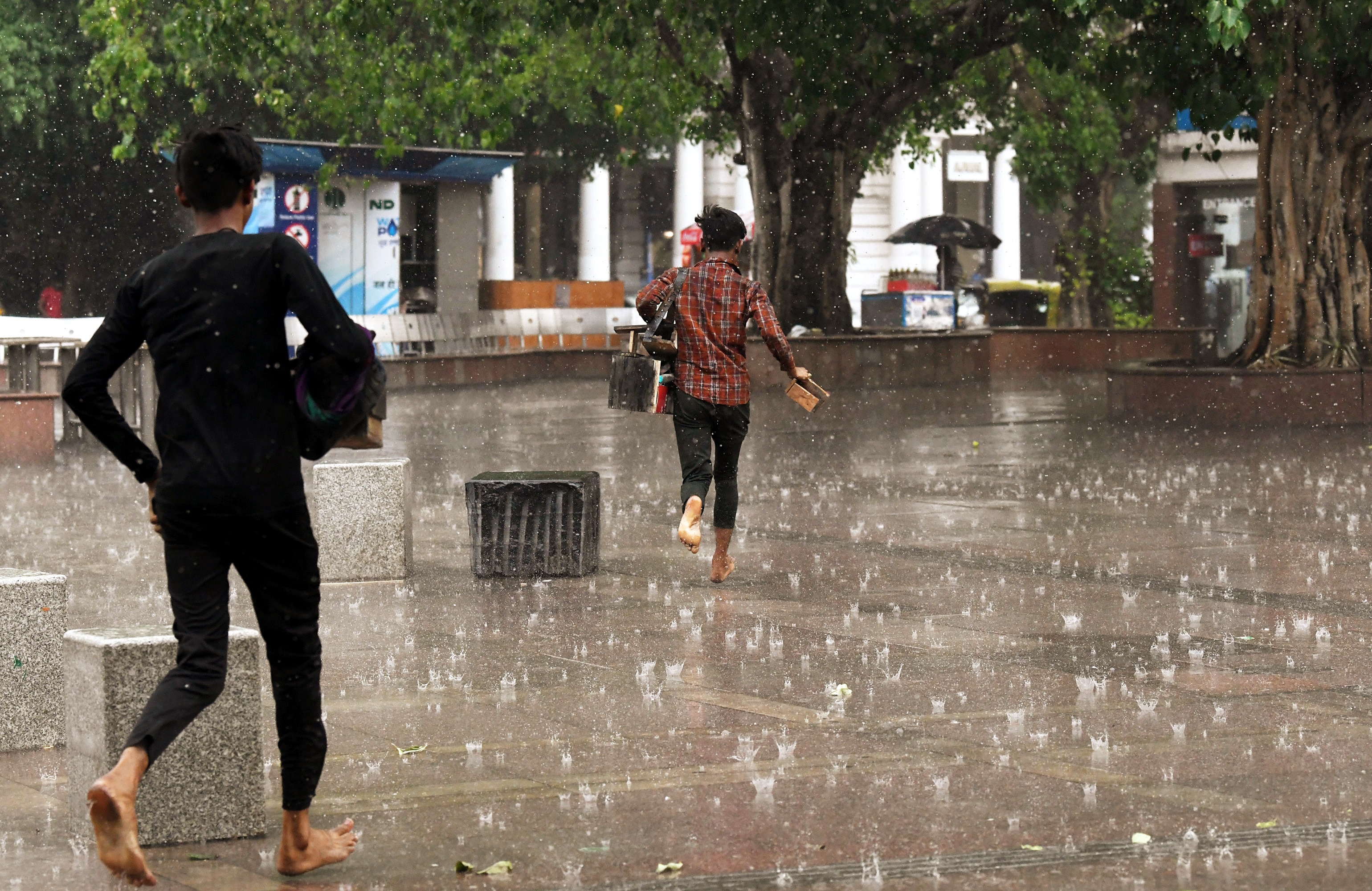 People run to take cover during a light rainfall, at Connaught Place, in New Delhi on May 6, 2022. (ANI photo) People run to take cover during a light rainfall, at Connaught Place, in New Delhi on May 6, 2022. (ANI photo)
