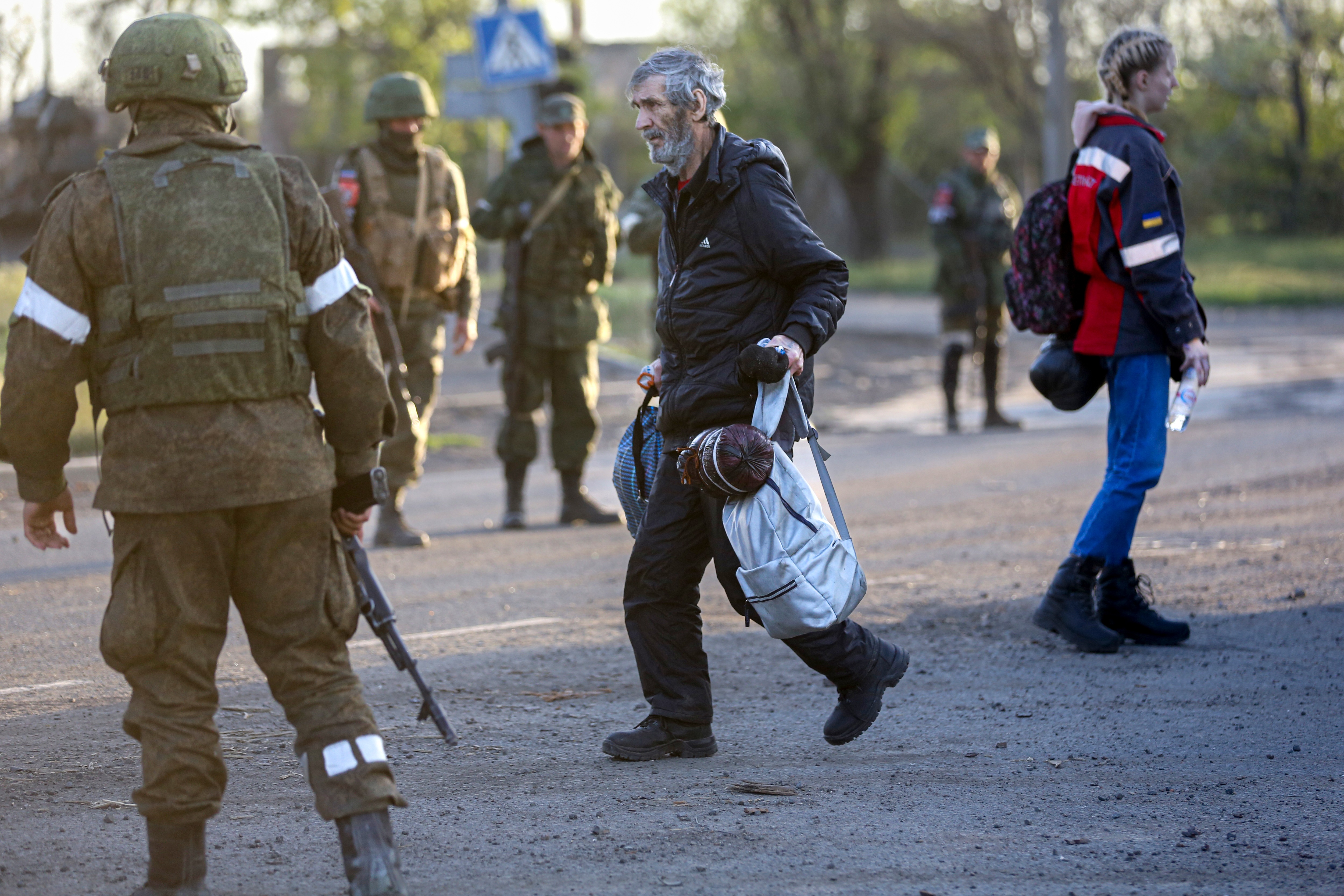 A man, who left a shelter in the Metallurgical Combine Azovstal walks to a bus between servicemen of Russian Army and Donetsk People’s Republic militia in Mariupol. (AP) A man, who left a shelter in the Metallurgical Combine Azovstal walks to a bus between servicemen of Russian Army and Donetsk People’s Republic militia in Mariupol. (AP)