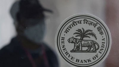 A man walks behind the Reserve Bank of India (RBI) logo inside its headquarters in Mumbai. (REUTERS)