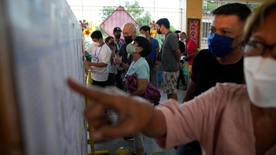 Residents look for their precincts on a list posted at a polling center on Monday, in Manila, Philippines. (AP)