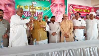 Former MP Harendra Malik presenting a ‘ gadaa’ and sword to governor Satyapal Malik during his felicitation by farmers in Muzaffarnagar on Sunday. (HT)