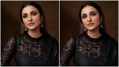 Parineeti wore the six yards in the traditional draping style, hugging her curvy frame, the pallu grazing the floor and the saree revealing her midriff. She teamed it with a matching black blouse featuring long sheer lace sleeves, floral embroidery and a ruffled neckline. (Instagram/@parineetichopra) Parineeti wore the six yards in the traditional draping style, hugging her curvy frame, the pallu grazing the floor and the saree revealing her midriff. She teamed it with a matching black blouse featuring long sheer lace sleeves, floral embroidery and a ruffled neckline. (Instagram/@parineetichopra)