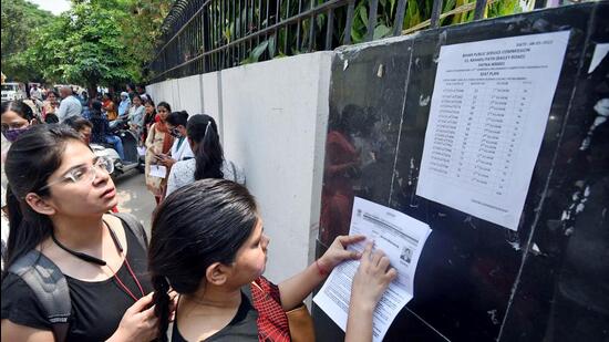 Aspirants search for their roll number on the notice board for the Bihar Public Service Commission (BPSC) 67th Prelims Exam 2022 , at an examination centre in Patna on Sunday. (ANI)