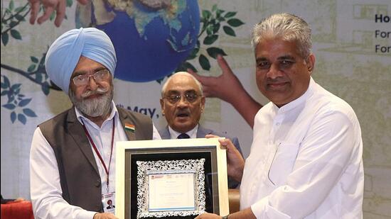 CU pro-chancellor RS Bawa presenting a memento to Union minister for environment Bhupender Yadav at a conference. (HT Photo)