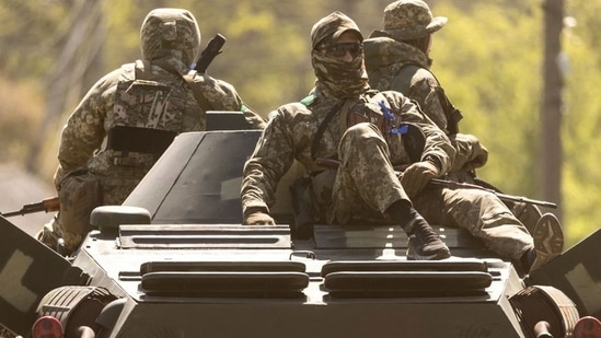 Ukrainian soldiers ride on an armored vehicle enroute to the front line, amid Russia's invasion in Ukraine, in Bakhmut in the Donetsk region on May 8, 2022.&nbsp;(Reuters photo)