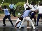 Supporters of Sri Lanka's ruling party hold down an anti-government demonstrator during a clash between the two groups in Colombo.