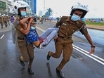 Policemen carry an injured man during a clash between government supporters and demonstrators outside the President's office in Colombo.(AFP)
