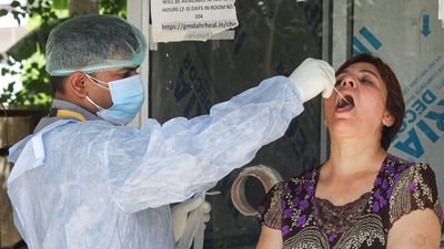A healthworker collects swab samples of residents for Covid-19 testing, in Gurugram. (File image) (PTI)