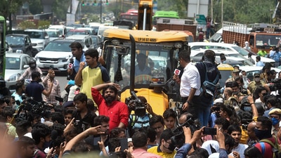 Locals stage a protest in front of an MCD bulldozer at Shaheen Bagh area during an anti-encroachment drive, in New Delhi, on Monday. (PTI)