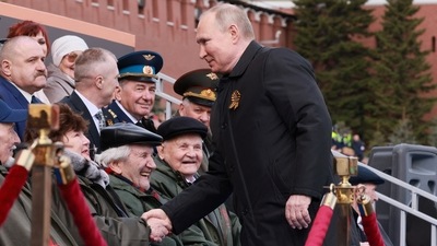 Russian President Vladimir Putin shakes hands with spectators before a military parade on Victory Day, which marks the 77th anniversary of the victory over Nazi Germany in World War Two, in Red Square in central Moscow, Russia. (via REUTERS)
