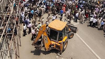 Around 11.30am, when the corporation vehicles and the team of officials started moving towards the market, a huge crowd had gathered on the road. The local residents who alleged ‘selective action’ by the BJP-ruled corporation, sat around the bulldozer. (ANI)