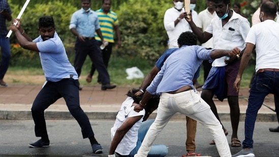 Supporters of Sri Lanka's ruling party hold down an anti-government demonstrator during a clash between the two groups in Colombo.(REUTERS)