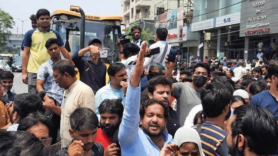 Locals protest in front of a bulldozer at Shaheen bagh in New Delhi on Monday.(Amal KS/HT Photo)