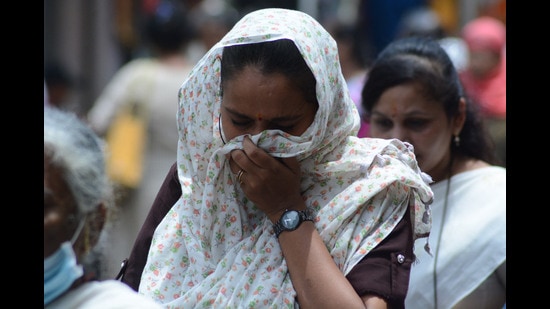Pedestrians cover themselves in the scorching afternoon heat while walking in the market as the mercury rises in the city, Thane, Mumbai, May 09, 2022 (Praful Gangurde/ HT PHOTO)