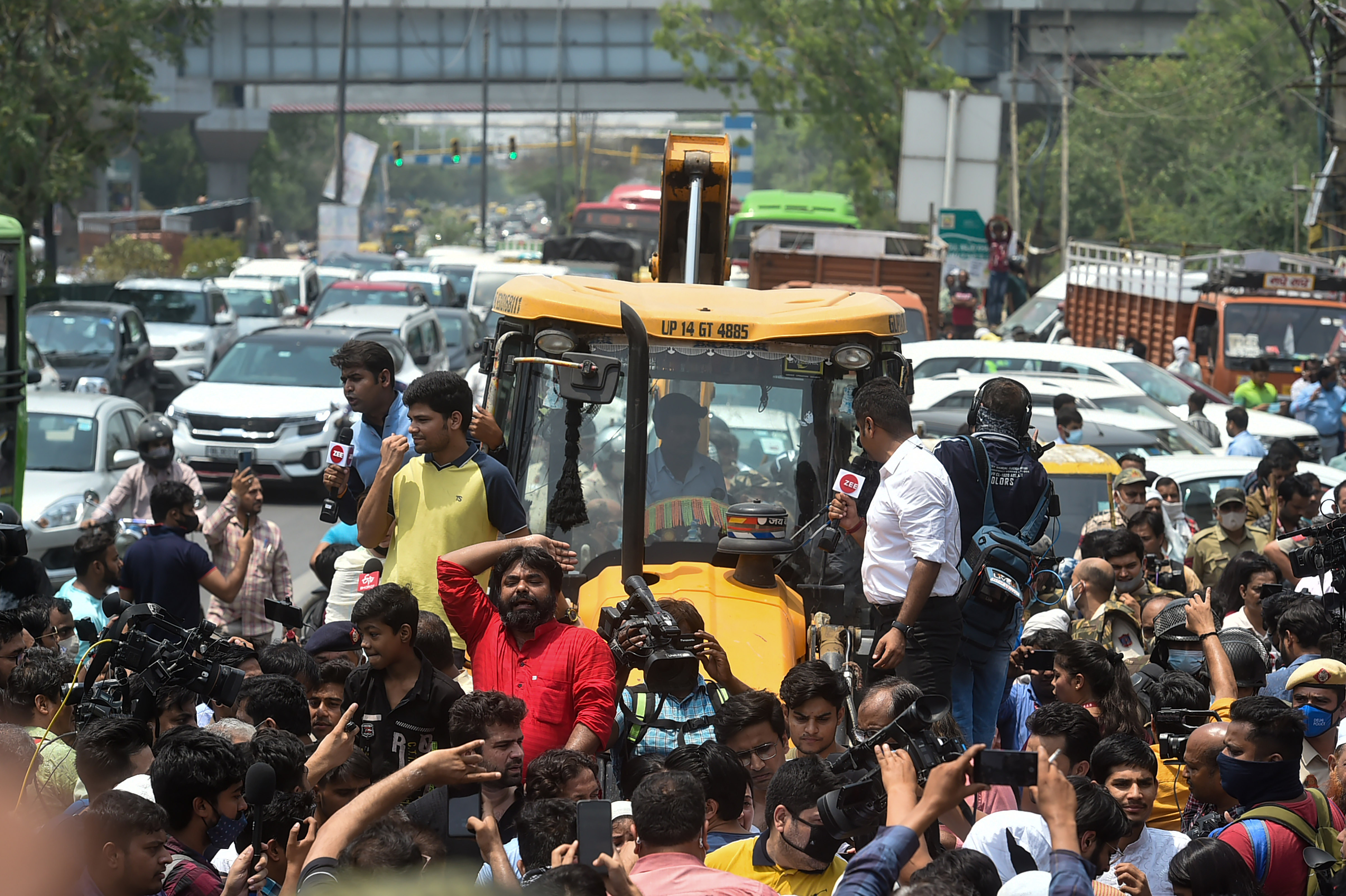 Locals stage a protest in front of an MCD bulldozer at Shaheen Bagh area during an anti-encroachment drive, in New Delhi, on Monday. (PTI)