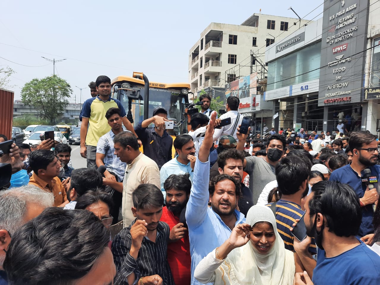 Locals protest in front of a bulldozer at Shaheen bagh in New Delhi on Monday. (Amal KS/HT Photo)