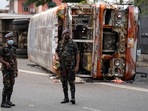 Sri Lankan soldiers stand guard next to burnt buses a day after clashes between government supporters and anti-government protesters in Colombo. Sri Lankan soldiers stand guard next to burnt buses a day after clashes between government supporters and anti-government protesters in Colombo.