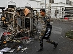 A security personnel walks past a burned vehicle near Sri Lanka's former prime minister Mahinda Rajapaksa's official residence 'Temple Trees', a day after they were torched by protesters in Colombo. A security personnel walks past a burned vehicle near Sri Lanka's former prime minister Mahinda Rajapaksa's official residence 'Temple Trees', a day after they were torched by protesters in Colombo.