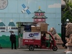 A delivery man passes through the entrance to a community in Beijing. A delivery man passes through the entrance to a community in Beijing.