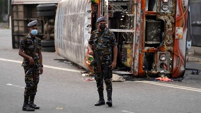 Sri Lankan soldiers stand guard next to burnt buses a day after clashes between government supporters and anti-government protesters in Colombo. (AP) Sri Lankan soldiers stand guard next to burnt buses a day after clashes between government supporters and anti-government protesters in Colombo. (AP)